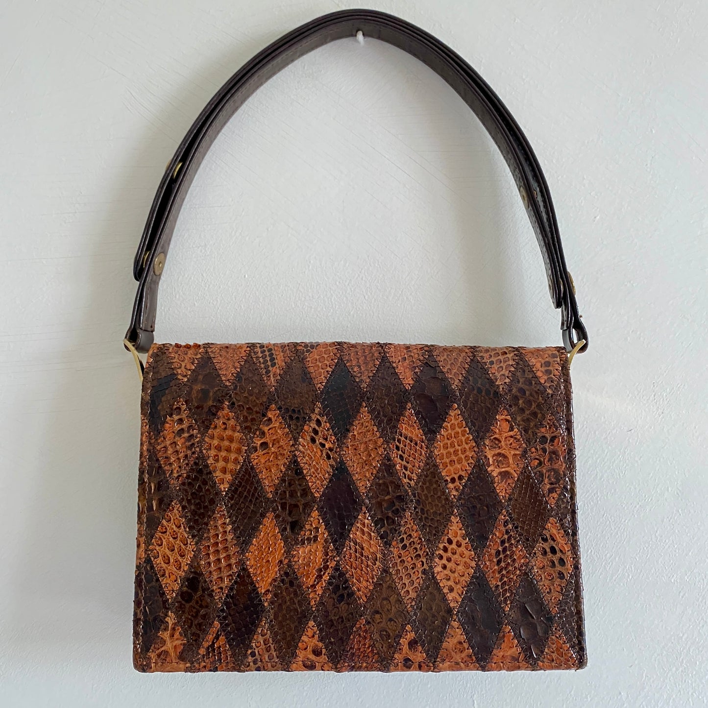 Brown leather geometric patchwork vintage bag Flap closure with press stud fastening Adjustable strap (measures from 19" to 30") Gold tone hardware Patchwork pattern to front and back Fabric lined Two inner compartments and one small zipped inner pocket