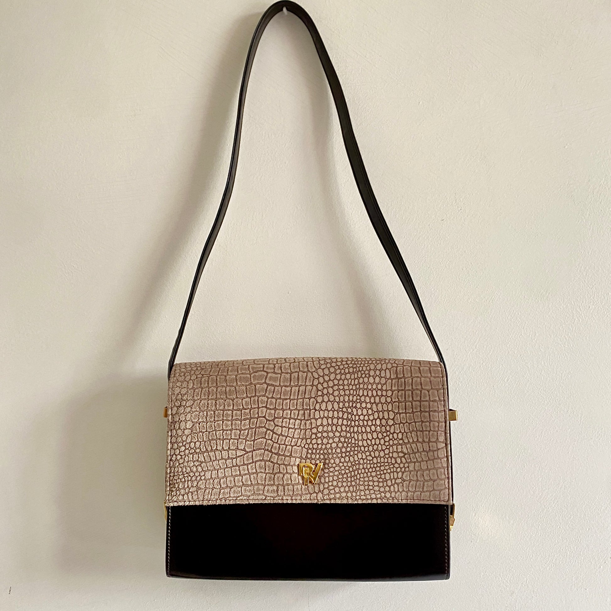 Late 80s dark brown vintage shoulder bag Contrast flap closure with magnetic press stud fastening  Shoulder strap measures 32" Gold tone hardware Three inner compartments (one with zip closure) Back pocket