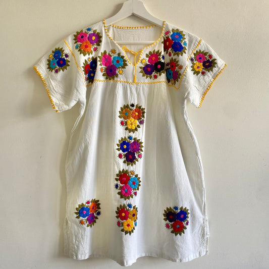 Vintage white cotton embroidered tunic top Hand embroidered decoration to front and sleeves Open neckline with tie detail Blanket stitch contrast edging  Small side splits Short sleeves 