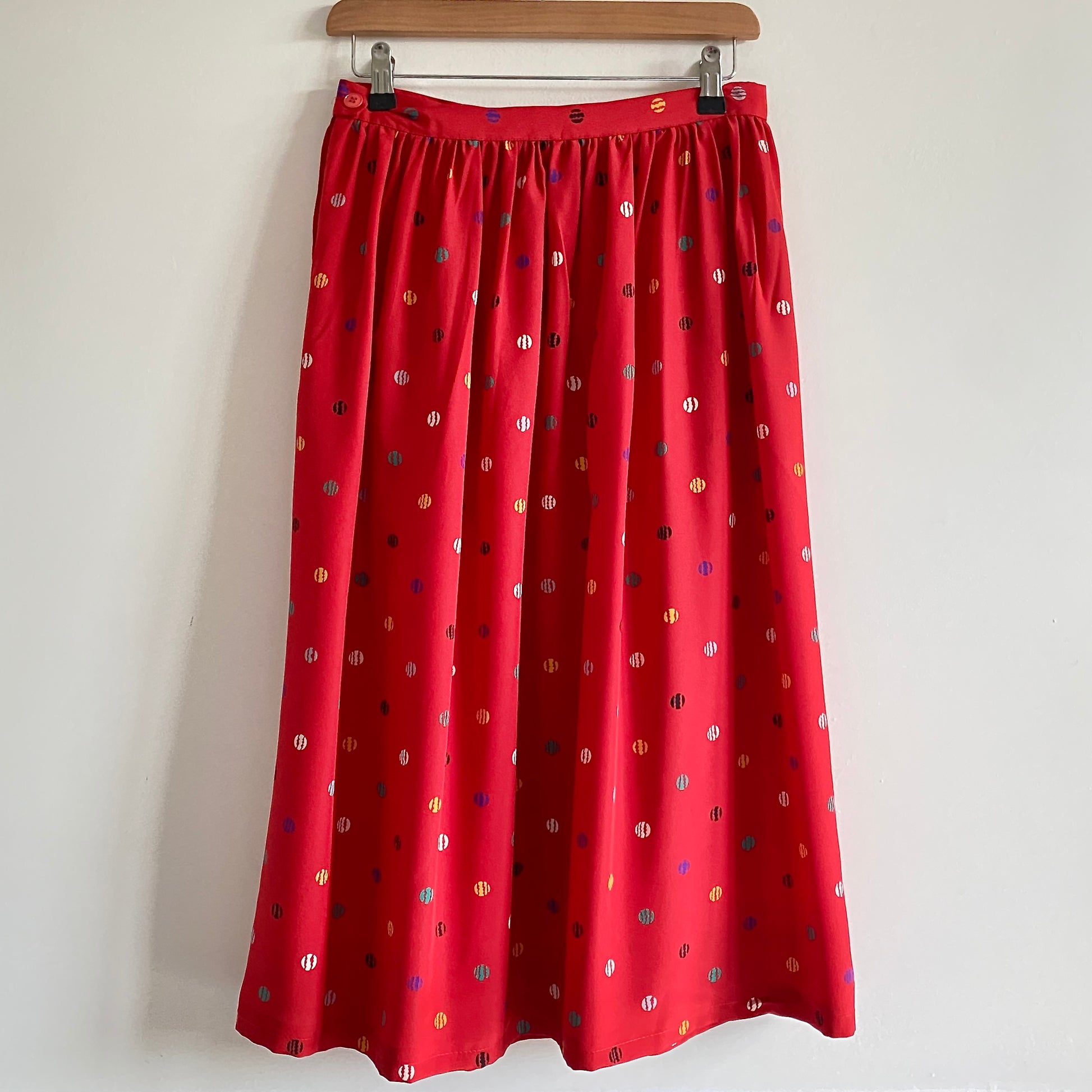      Vintage 80s red patterned midi skirt     By Chaus     Small waistband with side button fastening     Side pockets     Polyester feel fabric     Length 29"     Waist measures 28"